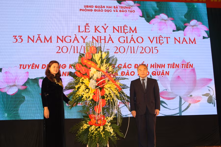 Trưởng phòng GD&ĐT Trần Lưu Hoa nhận lẵng hoa của Thứ trưởng Bộ GD&ĐT Nguyễn Vinh Hiển chúc mừng ngành GD-ĐT quận Hai Bà Trưng