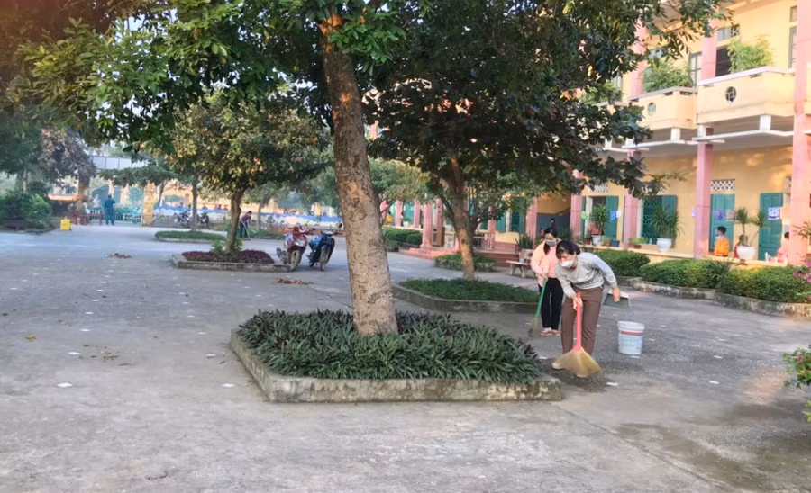 Các giáo viên thực hiện quét dọn vệ sinh khuôn viên trường trong sáng 26/10. Ảnh: L.Toàn.