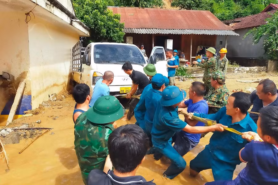 Bộ đội và dân quân tự vệ giải cứu một chiếc xe tải bị lũ cuốn và vùi lấp tại bản Hòa Sơn.