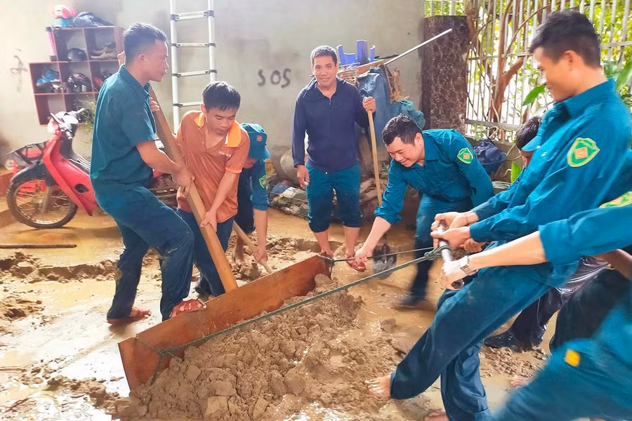 Bộ đội và dân quân giúp đỡ người dân dọn bùn đất ra khỏi nhà, đồng thời thu dọn đồ đạc sót lại sau trận lũ quét.