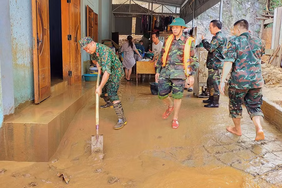Một ngày sau khi cơn lũ kinh hoàng quét qua, nhiều ngôi nhà ngập trong bùn đất.