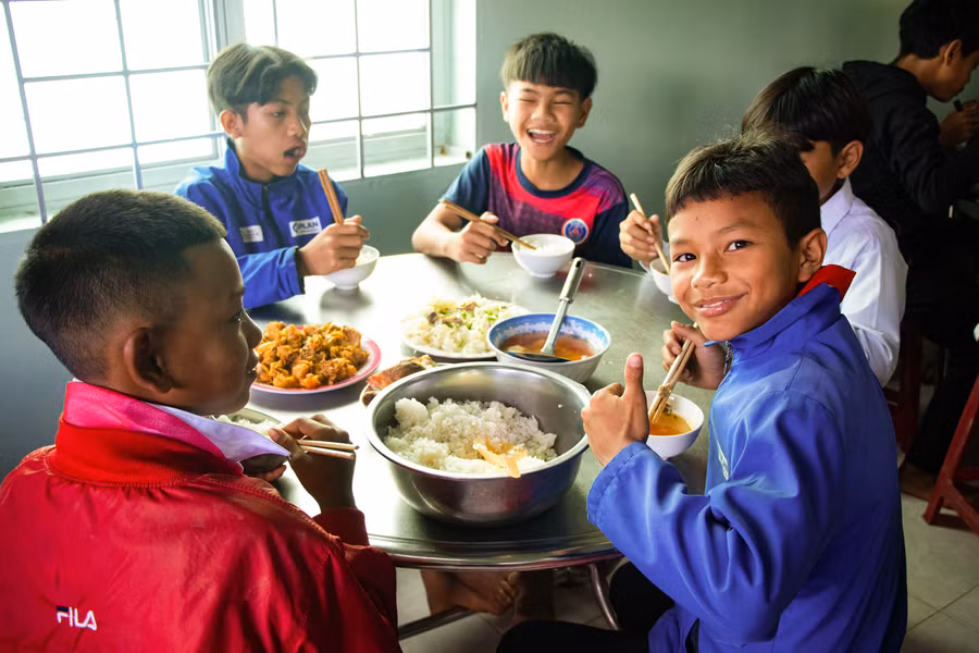 Các em nhỏ bên bữa cơm có thịt.