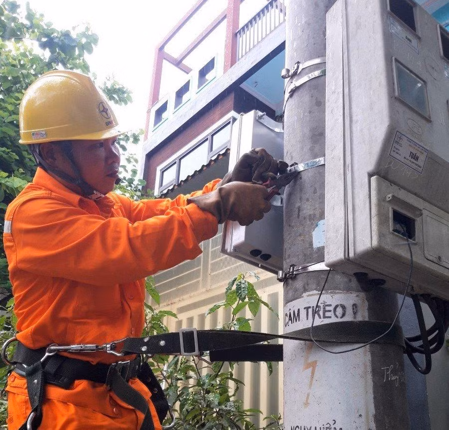 Công nhân Điện lực Than Uyên lắp đặt công tơ điện tử cho khách hàng.