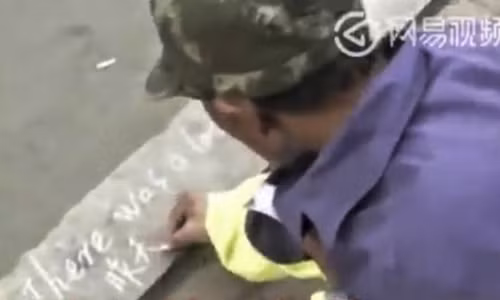Ông Wang Shoushan ôn tập tiếng Anh bằng cách viết lên vỉa hè. Ông Wang Shoushan ôn tập tiếng Anh bằng cách viết lên vỉa hè. Ảnh: News.163.com.