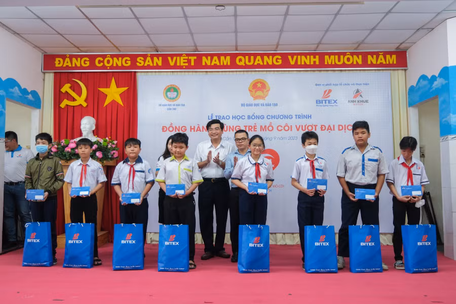 Đại diện lãnh đạo Bộ GD&amp;ĐT, Sở GD&amp;ĐT, công ty BITEX trao học bổng cho học sinh.