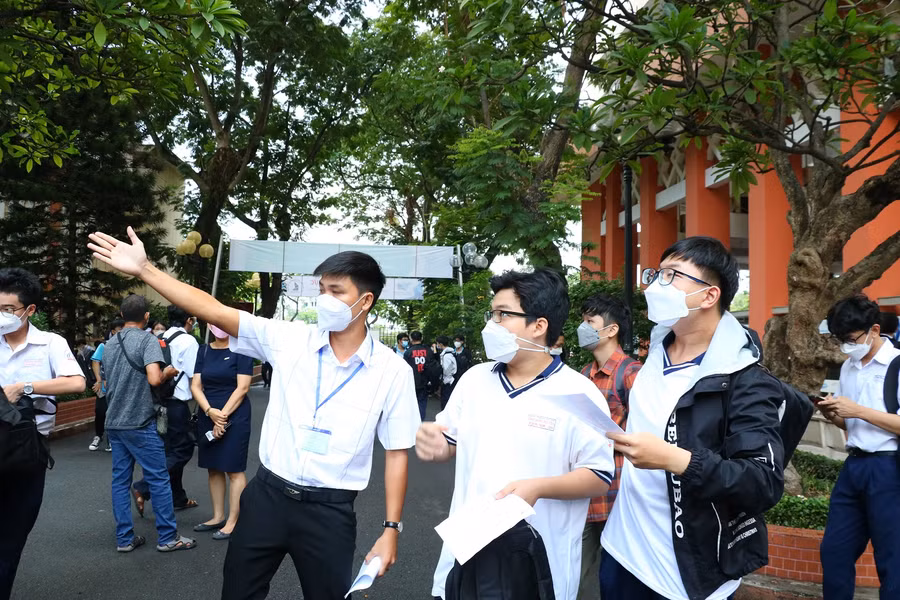 Tình nguyện viên hướng dẫn thí sinh tham dự kỳ thi ĐGNL của ĐHQG TPHCM vào phòng thi.