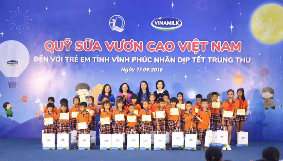 Bà Trương Thị Mai - Uỷ viên Bộ chính trị, bí thư Trung ương Đảng, trưởng ban dân vận Trung ương; bà Nguyễn Thị Hà - Thứ trưởng Bộ Lao động - Thương Binh và Xã hội; bà Hoàng Thị Thuý Lan - bí thư tỉnh uỷ Vĩnh Phúc và bà Bùi Thị Hương - Giám đốc Điều hành Vinamilk trao quà và sữa cho các em học sinh