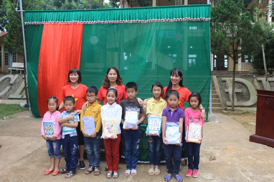 Ban giám hiệu Trường tiểu học Hoàng Hoa Thám tặng quà cho học sinh Trường tiểu học xã Thạch Định