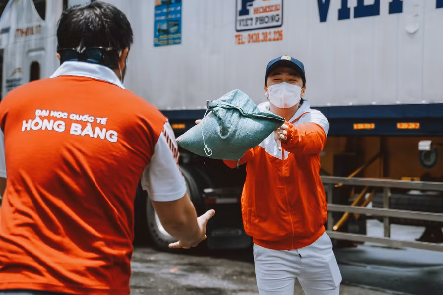 Sinh viên ĐH Quốc tế Hồng Bàng đang chuyển hàng hóa từ xe xuống để chuyển đến người dân cần hỗ trợ
