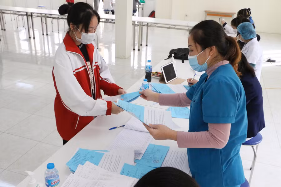 Sau 30 phút, các em được gọi tên để lên lấy giấy xác nhận đã tiêm mũi 1 vắc xin phòng Covid-19 từ nhân viên y tế.