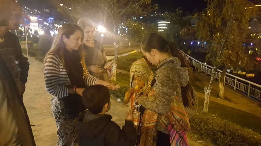 Mẹ con Giàng Thị Mú bán hàng cho khách Tây Phía sau những đứa trẻ bán hàng rong ở Sa Pa