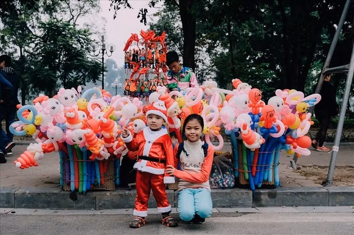 Gần đó, tại phố đi bộ Hồ Gươm nhiều gia đình tìm cho mình những cách riêng để tận hưởng không khí Giáng sinh an lành. Các em nhỏ với những món đồ chơi mang nét đặc trưng của Noel cùng tung tăng bước đi bên bố mẹ.