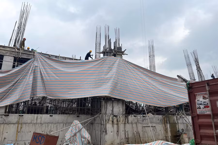 Công nhân cùng máy móc đang dọn sắt, xúc bê tông hư hỏng khỏi hiện trường.