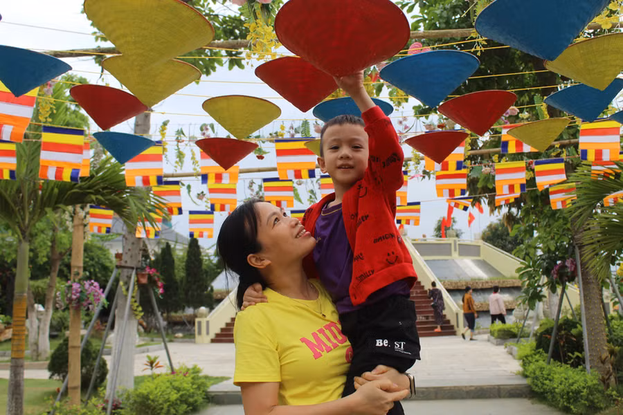Lần đầu cùng con tới vãn cảnh chùa, chị Lê Thị Thắm (TP Thanh Hóa, người trong ảnh) vô cùng ấn tượng với kiến trúc độc đáo của ngôi chùa. "Không gian của ngôi chùa này rất thoáng mát, lại sát ngay cửa biển. Kiến trúc ngôi chùa cũng rất độc và lạ. Tôi dự định rủ thêm bạn bè tới tham quan và chụp ảnh lưu niệm", người phụ nữ này chia sẻ. Ảnh: LT.