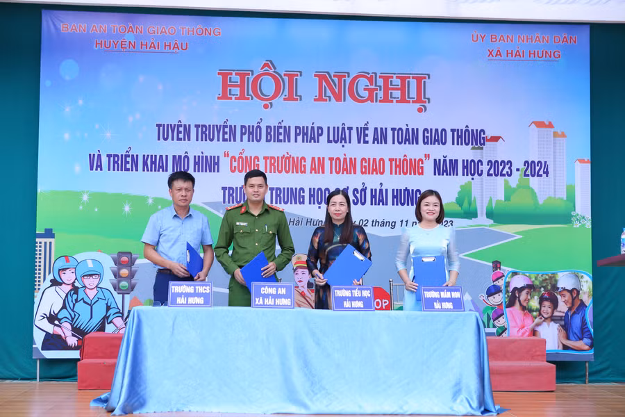 Đại diện Công an xã Hải Hưng và lãnh đạo 3 trường Mầm non, Tiểu học, THCS xã cùng ký cam kết thực hiện mô hình "Cổng trường an toàn giao thông".