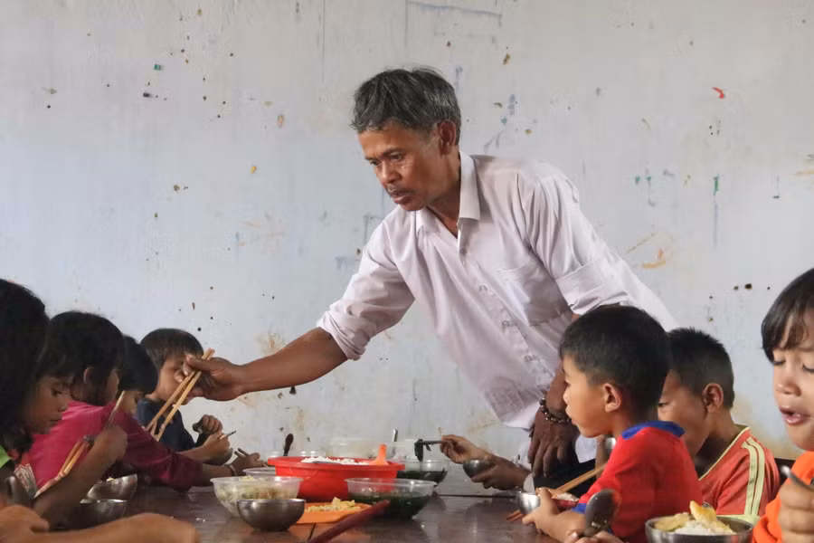 Thầy A Phiên lo từng bữa ăn cho HS.