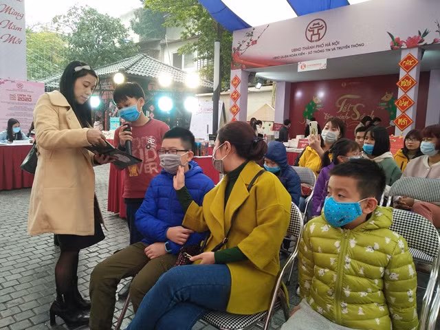 Không ai cảm thấy khó chịu với chiếc khẩu trang khi đọc sách tương tác tại Phố sách Xuân Canh Tý 2020. Ảnh: Bình Thanh