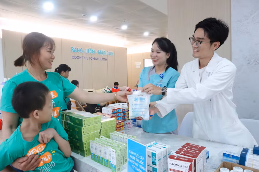 Gia đình 1 em nhỏ nhận thuốc miễn phí từ Chương trình. (Ảnh: TT)