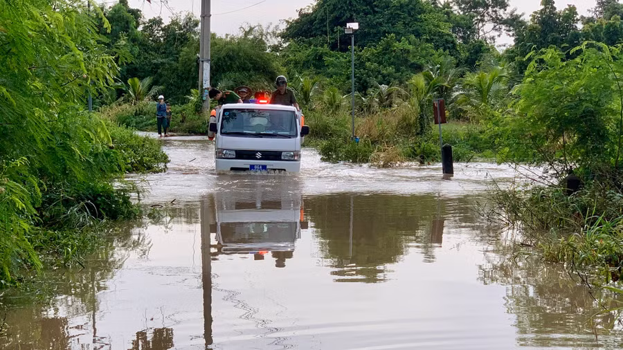 Lực lượng Công an xã Hàm Thạnh dùng xe chuyên dụng đưa học sinh, người dân qua điểm ngập lụt. (Ảnh: QT)