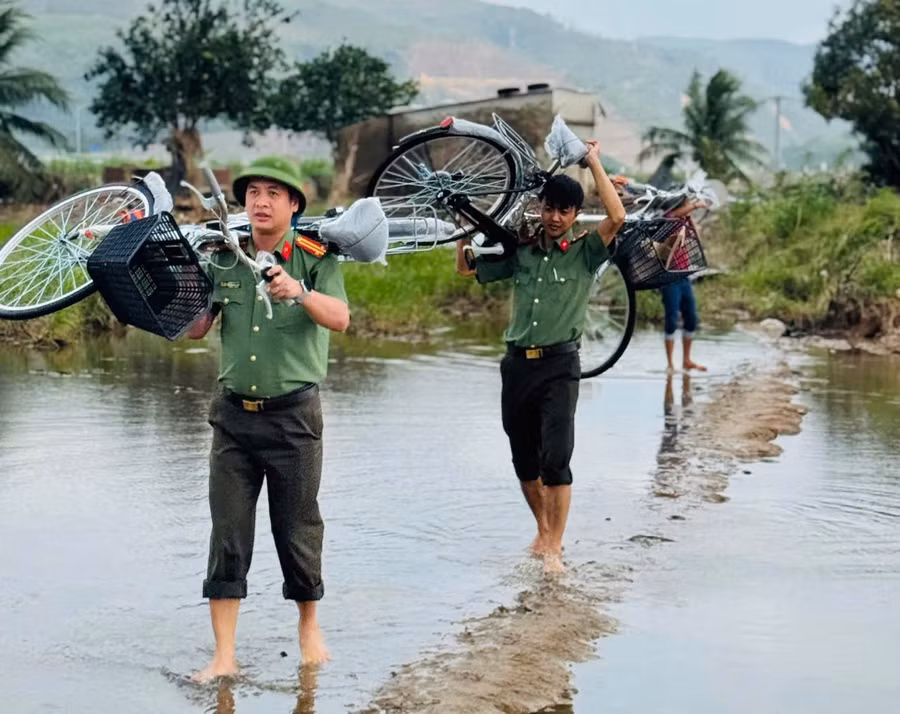 Cán bộ, chiến sĩ Công an Đắk Lắk vượt suối mang niềm vui đến thầy và trò Trường Tiểu học Phú Mỡ. (Ảnh: TT)