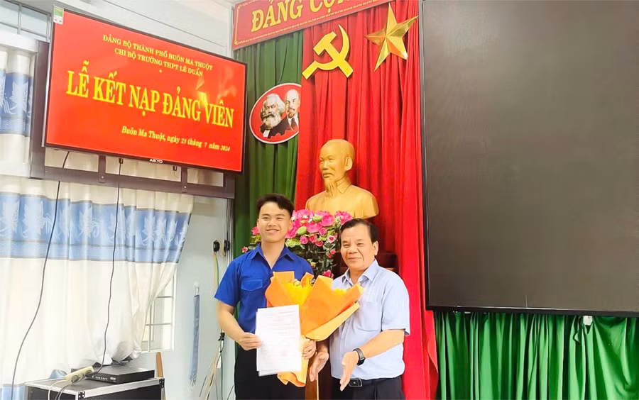 Thầy Phạm Văn Sinh, Bí thư Chi bộ, Hiệu trưởng Trường THPT Lê Duẩn trao quyết định kết nạp đảng cho học sinh (Ảnh: TT)