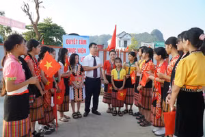 Thầy Nguyễn Lê Tú - giáo viên Trường Phổ thông nội trú TH&THCS Anh Sơn (Nghệ An) đón học sinh từ bản Cao Vều. Ảnh: Hồ Lài