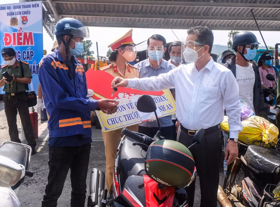 Ông Nguyễn Văn Quảng - Bí thư Thành ủy Đà Nẵng (áo sơ mi trắng) trao tặng xe máy cho người dân khó khăn trên đường đi về quê. 