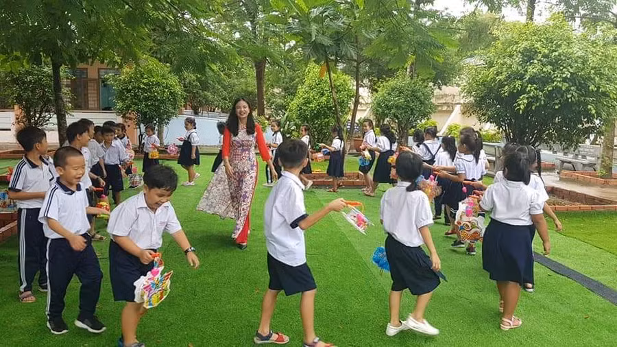 Cô Lê Thị Kim Thúy - Hiệu trưởng Trường TH Phú Hòa 3 cùng học trò vui chơi trong công viên xanh đầy ắp tiếng cười hạnh phúc (Ảnh: NTCC)