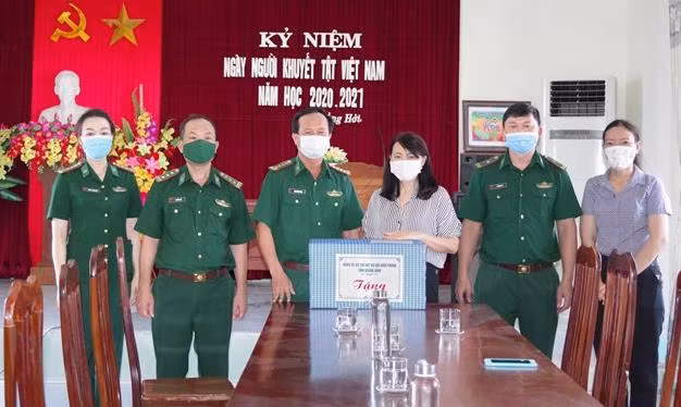 Đại tá Đinh Xuân Hùng, Phó Chính ủy Bộ đội biên phòng Quảng Bình tặng quà cho trẻ khuyết tật tại Trung tâm Nuôi dạy trẻ khuyết tật TP Đồng Hới