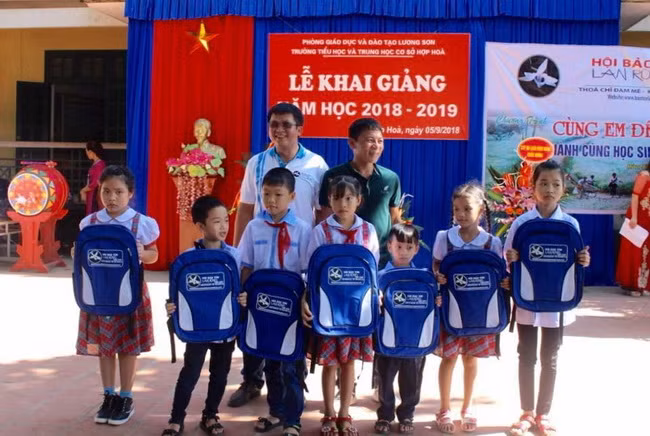 Đại diện Ban tổ chức tặng học bổng và cặp sách cho HS có hoàn cảnh khó khăn trường Tiểu học &THCS Hiệp Hòa.