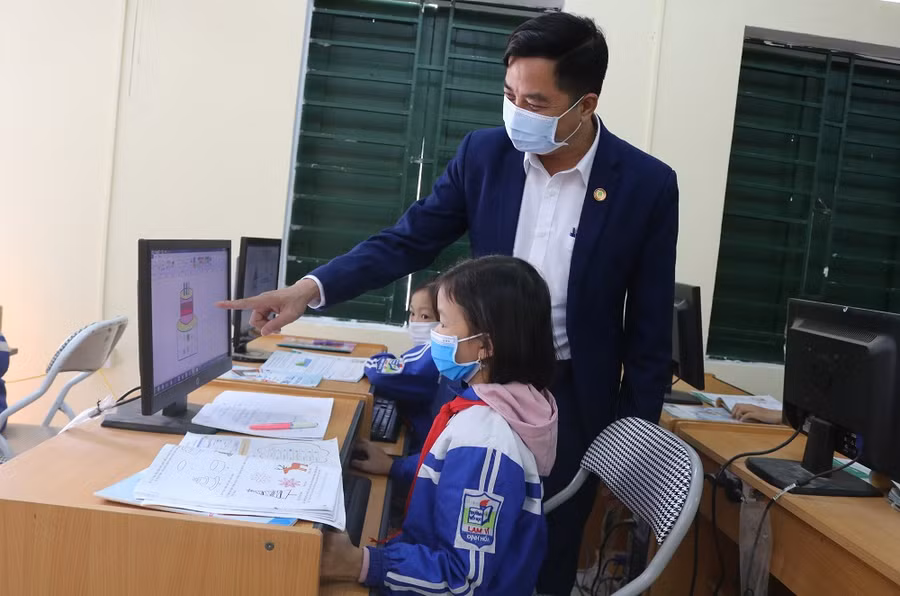 Thầy giáo Nguyễn Công Liệu cùng các học trò trong phòng tin học nhà trường