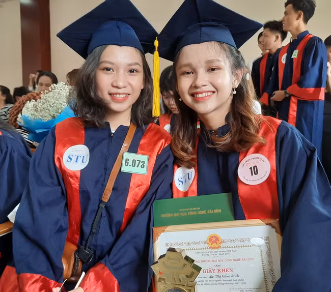 SV Lê Thị Cẩm Linh (bên trái) -Thủ khoa Khoa Công nghệ Thực phẩm vui mừng khi nhận bằng tốt nghiệp