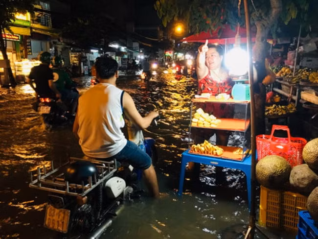 Người dân quận 7- TPHCM, vất vả mưu sinh khi nước ngập do triều cường ( Ảnh: C.Chương)