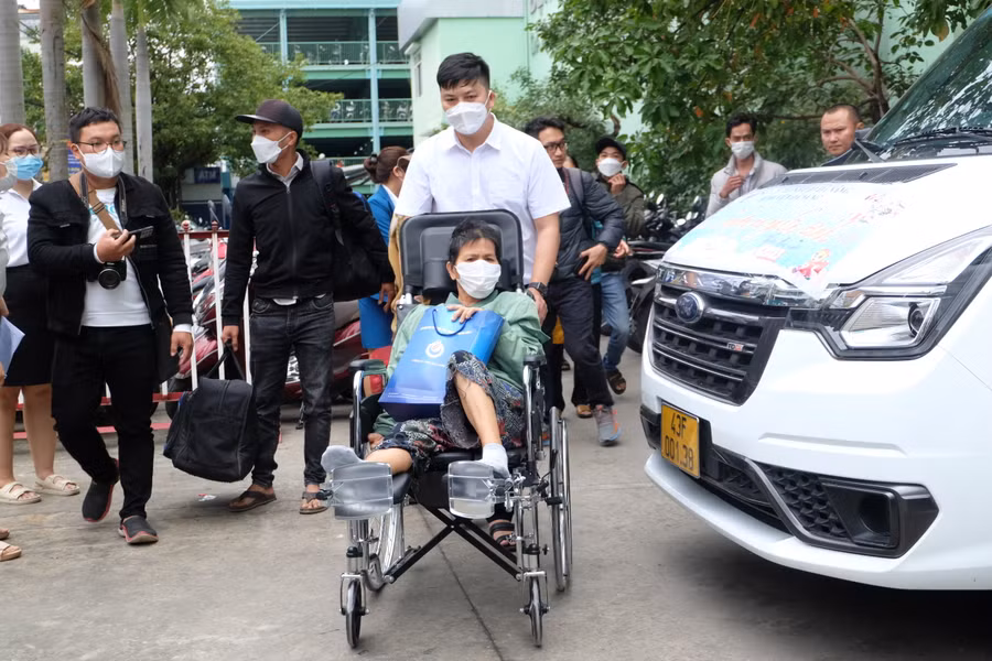 Nhân viên y tế của Bệnh viện Đà Nẵng đưa các bệnh nhân lên chuyến xe nghĩa tình. Ảnh: Hoàng Vinh.