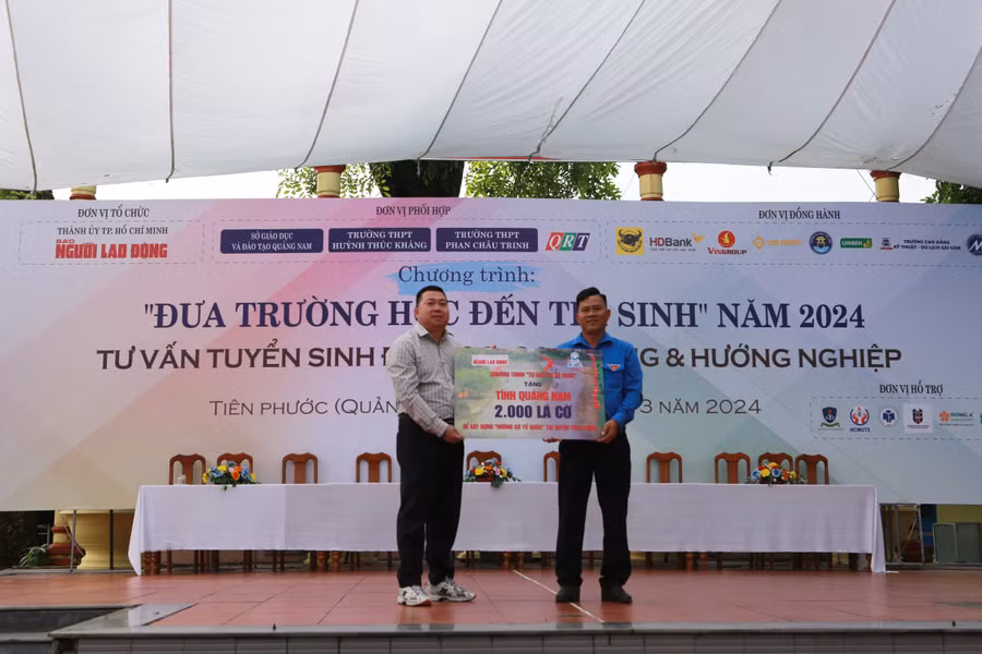 Nhà báo Đặng Hoàng Dũng (bên trái) - Báo Người Lao động trao Huyện đoàn Tiên Phước 2.000 lá cờ Tổ quốc.