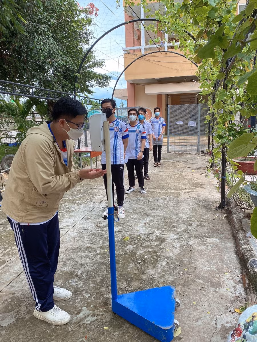Học sinh đến điểm thi Trường THPT Chuyên Long An được đo thân nhiệt và sát khẩu để phòng dịch (Ảnh: NTCC)