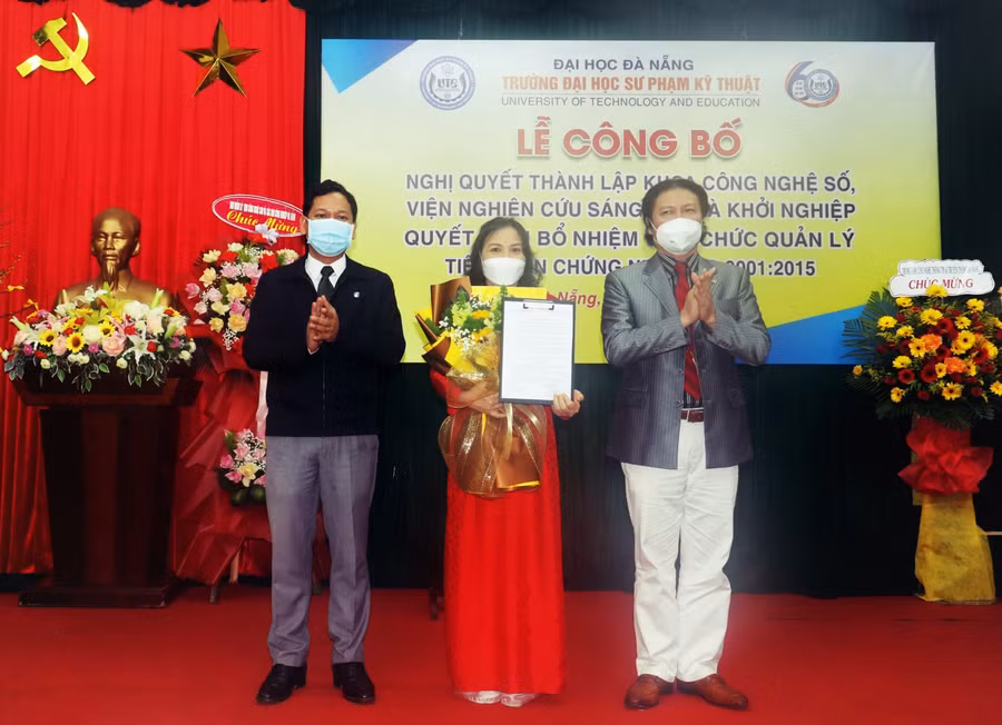 PGS.TS Phan Cao Thọ (bìa phải) - Hiệu trưởng Trường ĐH Sư phạm Kỹ thuật (ĐH Đà Nẵng) trao quyết định bổ nhiệm cho TS. Hoàng Thị Mỹ Lệ - giữ chức vụ Phó Trưởng khoa Khoa Công nghệ số.
