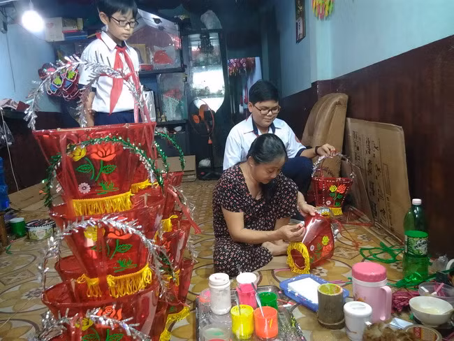 Bà Tuyết đang hoàn thiện khâu in trang trí cho chiếc lồng đèn. Bà Tuyết đang hoàn thiện khâu in trang trí cho chiếc lồng đèn.