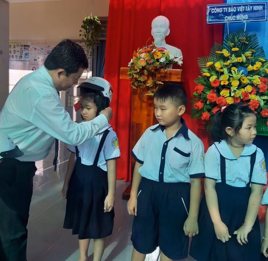 Ông Phạm Ngọc Hải, Phó GĐ Sở GD&amp;ĐT Tây Ninh trao tặng mũ bảo hiểm cho các em học sinh (Ảnh:Sở cung cấp)