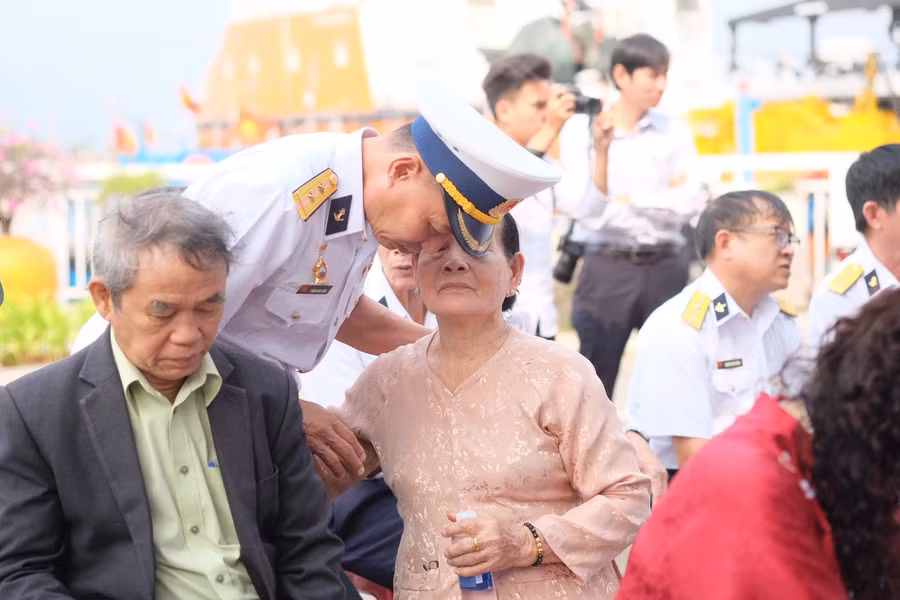 Đồng đội bên cạnh người thân của các liệt sĩ.
