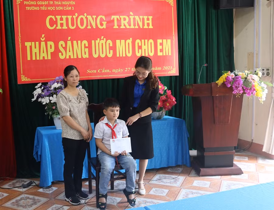 Cô giáo Trần Thị Quỳnh Trang, Bí thư Đoàn trường THPT Lương Ngọc Quyến trao hỗ trợ cho em Huy cùng gia đình