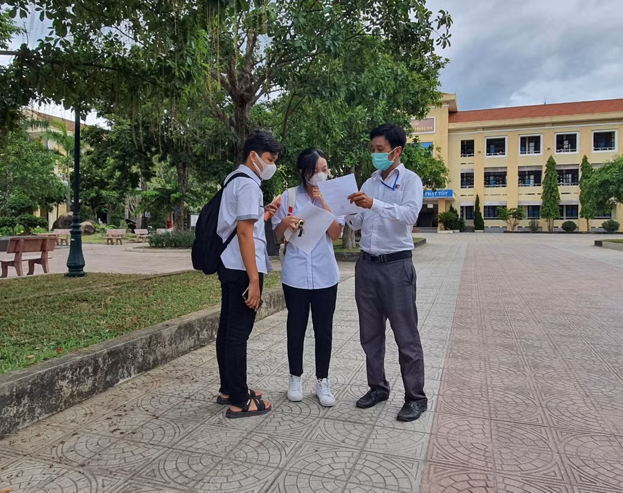 Một số thí sinh trao đổi với giáo viên sau khi kết thúc môn thi.