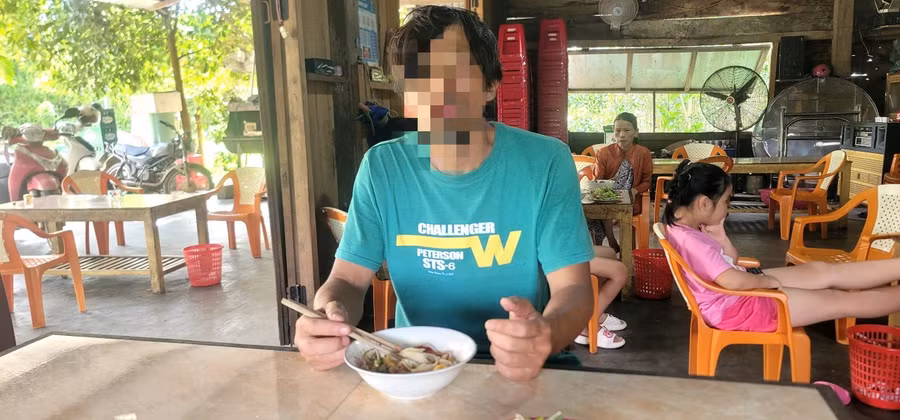 Anh K. lúc đi lạc được công an hỗ trợ ăn uống. Ảnh: Công an