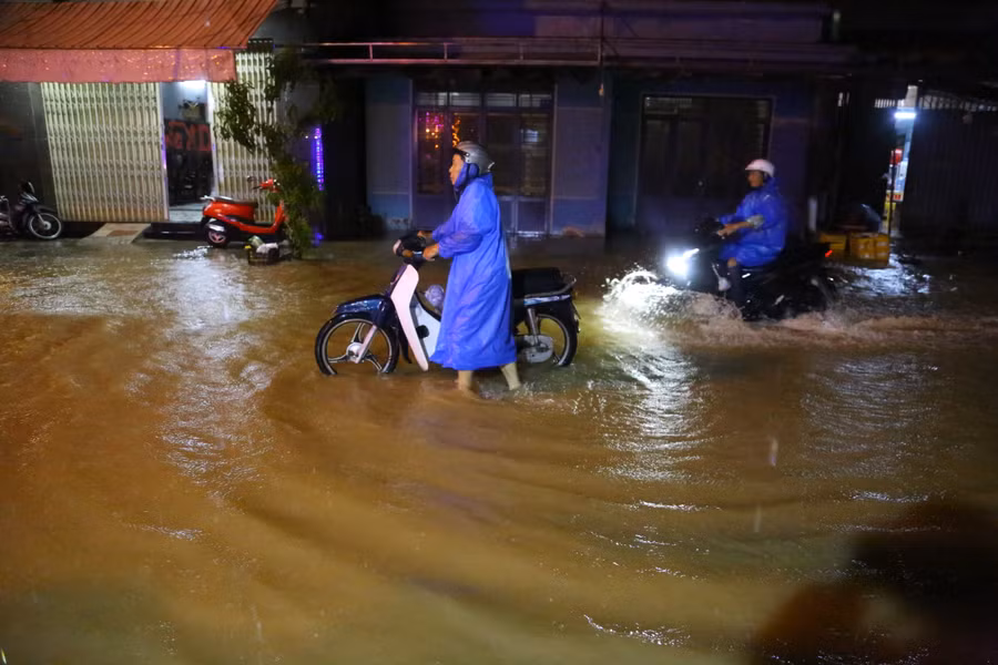 Dắt xe ra khỏi khu vực ngập nước. (Ảnh: Hoàng Vinh)