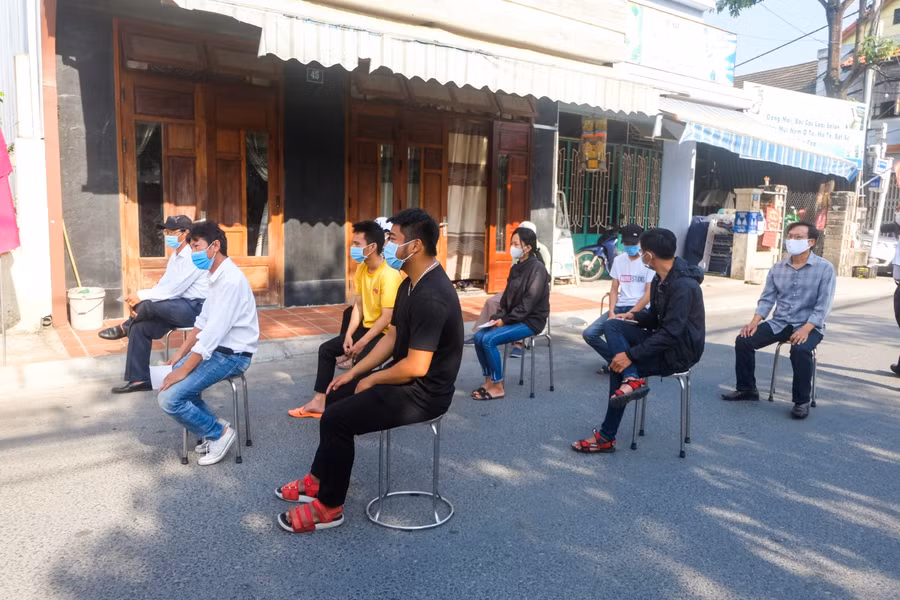 Cử tri ngồi giãn cách xếp hàng trước khi vào khu vực bầu cử.