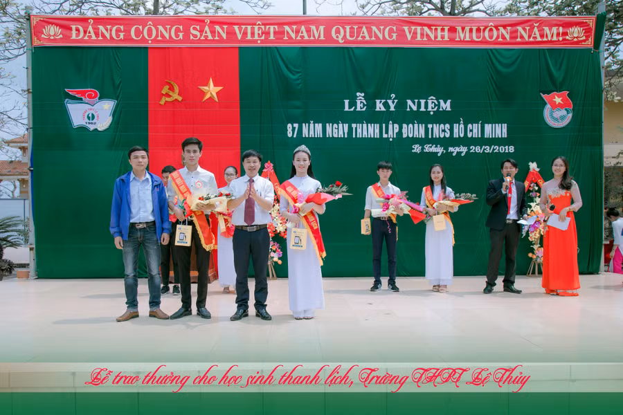 Thầy Hà Văn Trung - Hiệu trưởng Trường THPT Lệ Thuỷ (thứ 2 từ phải sang) trao thưởng cho học sinh thanh lịch của trường.
