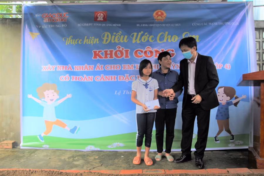 Ông Nguyễn Văn Vững - Trưởng phòng GD&amp;ĐT huyện Lệ Thủy trao quà cho 2 mẹ con em Quỳnh Hoa.