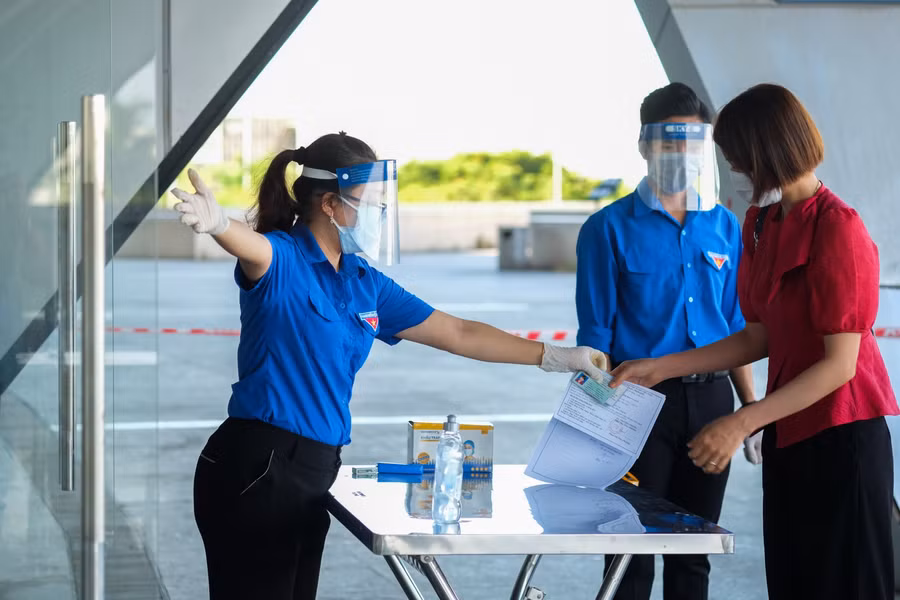 Đoàn viên thanh niên sẽ kiểm tra giấy tờ của người dân trước khi vào khu vực tiêm.