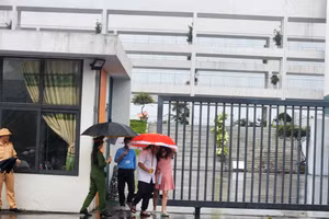 Các thí sinh rời phòng thi trong thời tiết có mưa.