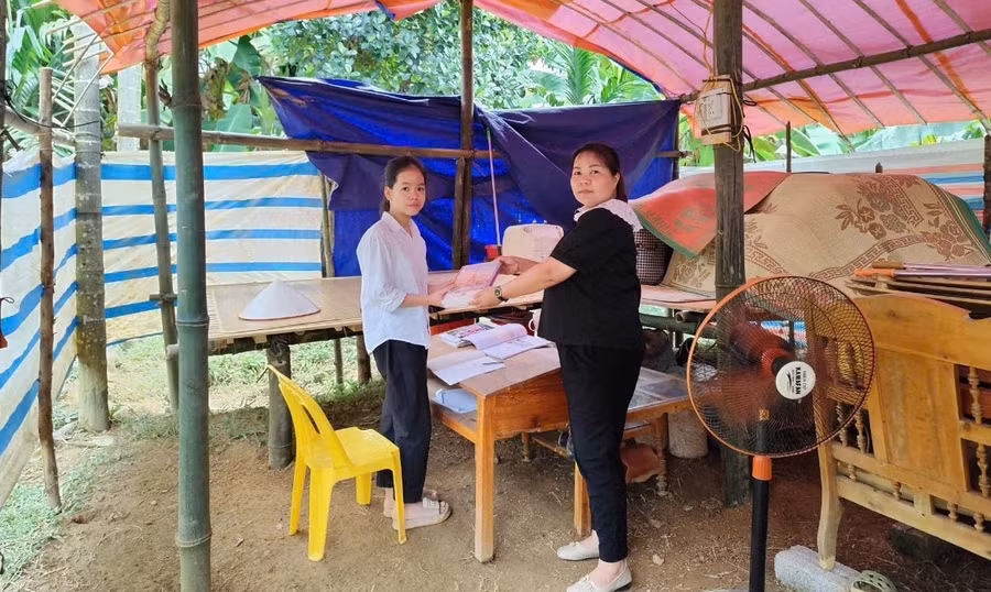 Cô giáo Hoàng Thị Như Oanh, Hiệu trưởng Trường TH&THCS Phúc Ninh cùng nhà trường thăm hỏi, động viên em Nông Thị Huyền Trang tại góc học tập bên lán tạm.